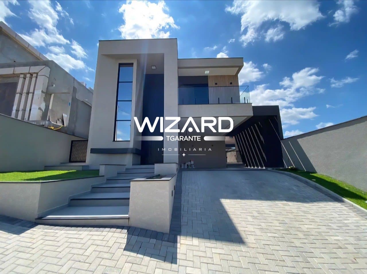 Fachada de casa contemporânea com garagem coberta, escada de entrada e detalhes em vidro.