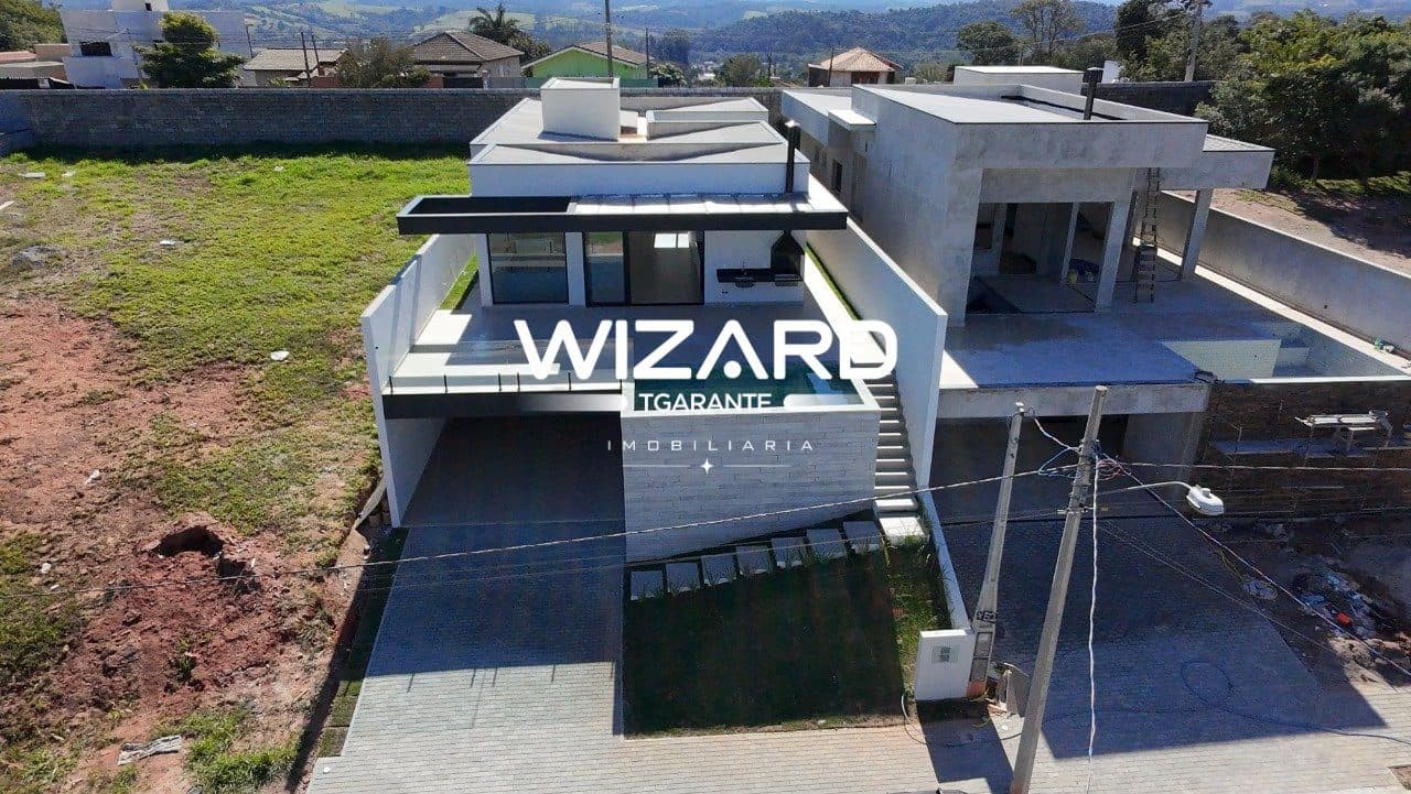 Vista aérea da fachada da casa com piscina e garagem.