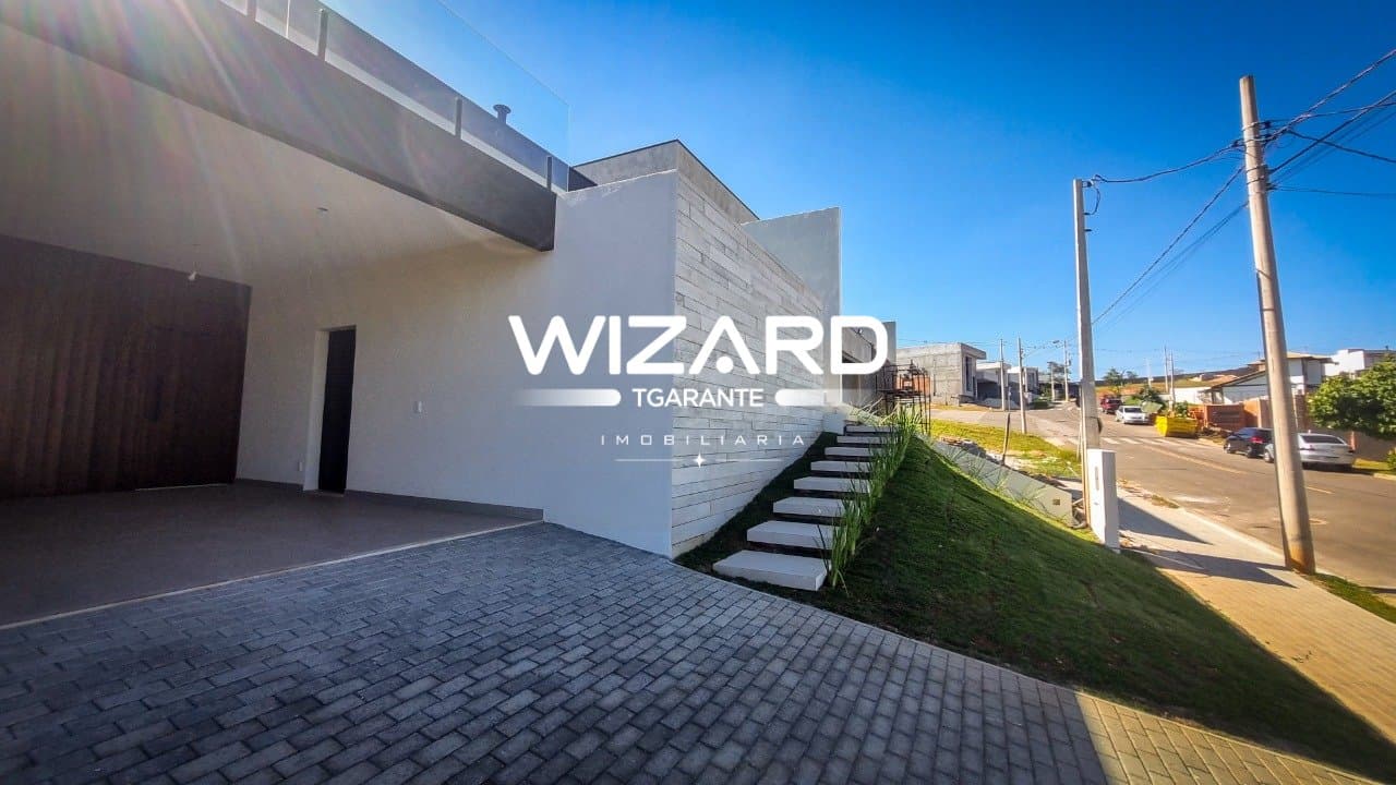 Fachada da casa com garagem coberta, escada externa e revestimento em pedra.
